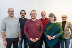 Gruppenbild mit sechs Personen vor weißem Hintergrund